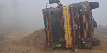Overturned lorry after fog-related accident in Rajavommangi mandal
