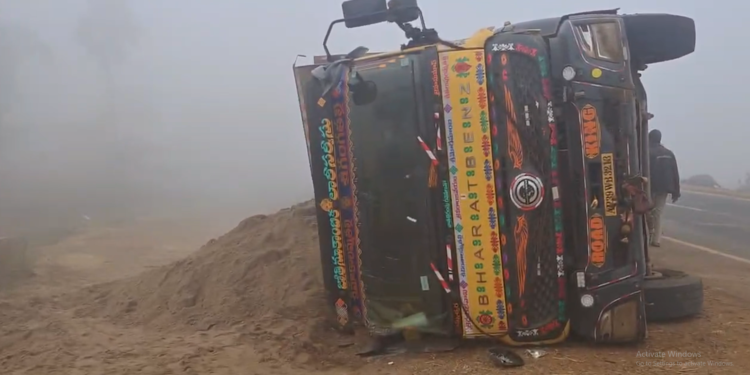 Overturned lorry after fog-related accident in Rajavommangi mandal