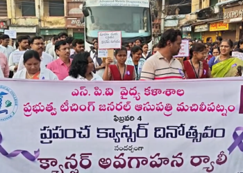 Students and officials holding banners during Krishna district cancer awareness rally