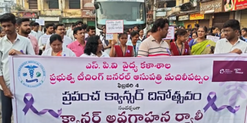 Students and officials holding banners during Krishna district cancer awareness rally